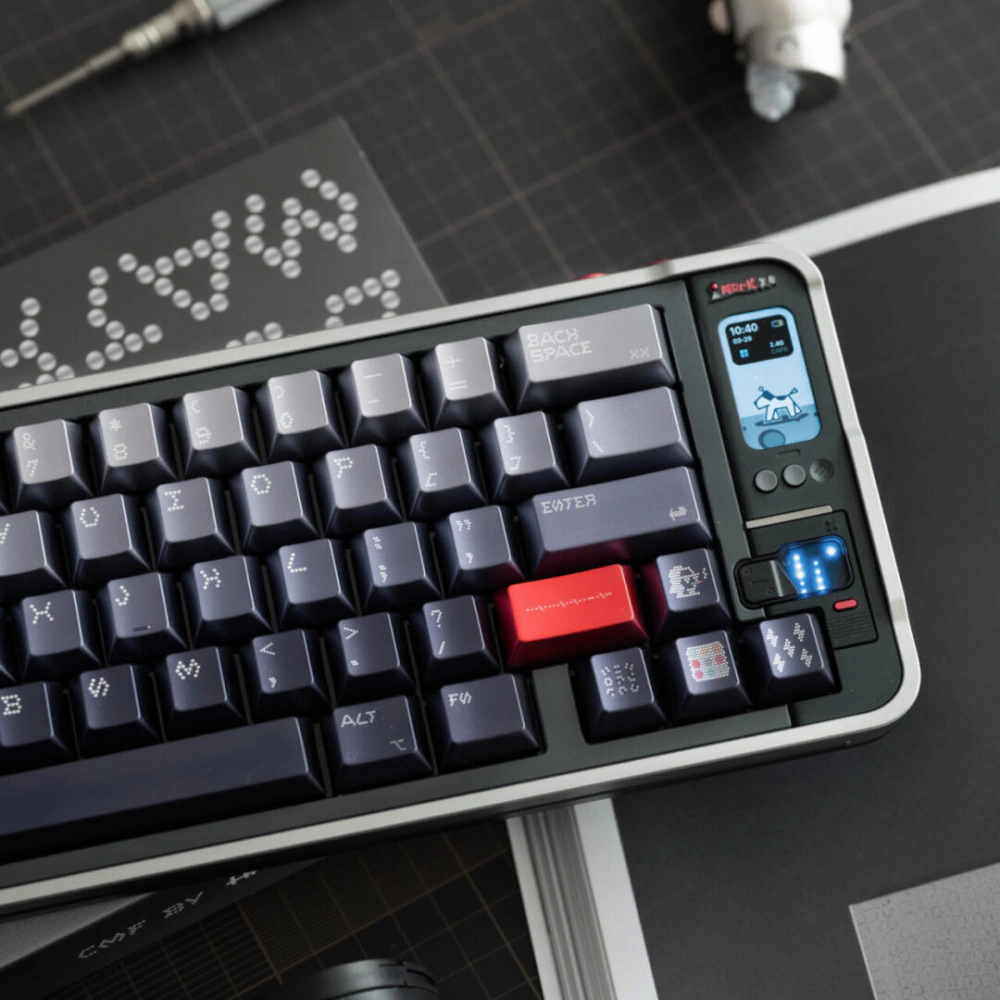 Keyboard corner with gray dot-matrix keycaps next to a blue digital display.