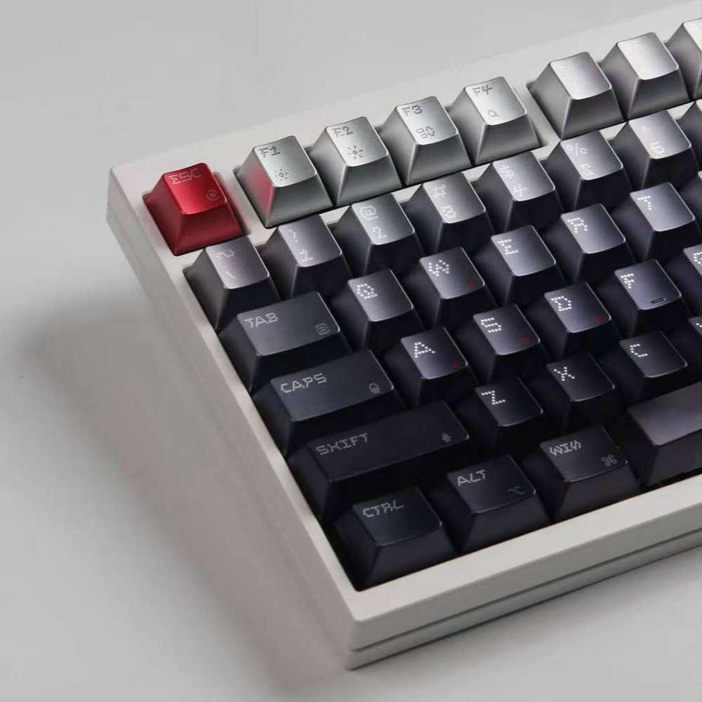 Red Esc key beside silver upper keys and dark dot-matrix rows on a light case.