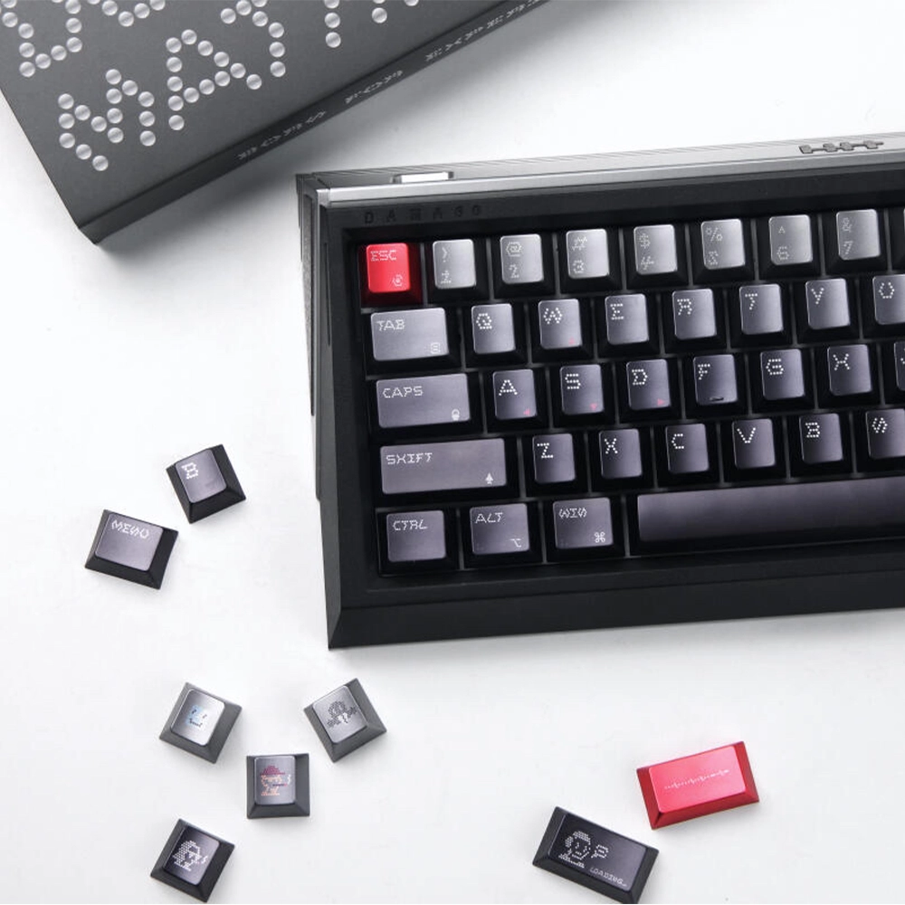 Individual keycaps with dotted and illustrated legends arranged beside part of a keyboard.