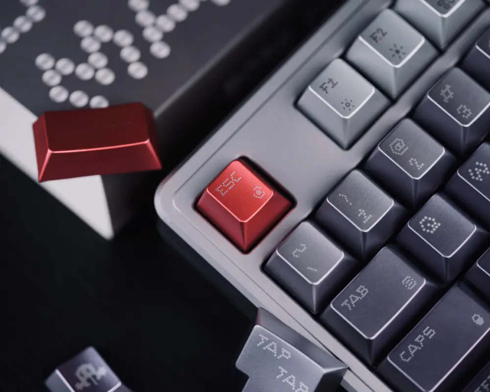 Red Esc key beside silver and charcoal keys with dot-matrix legends.