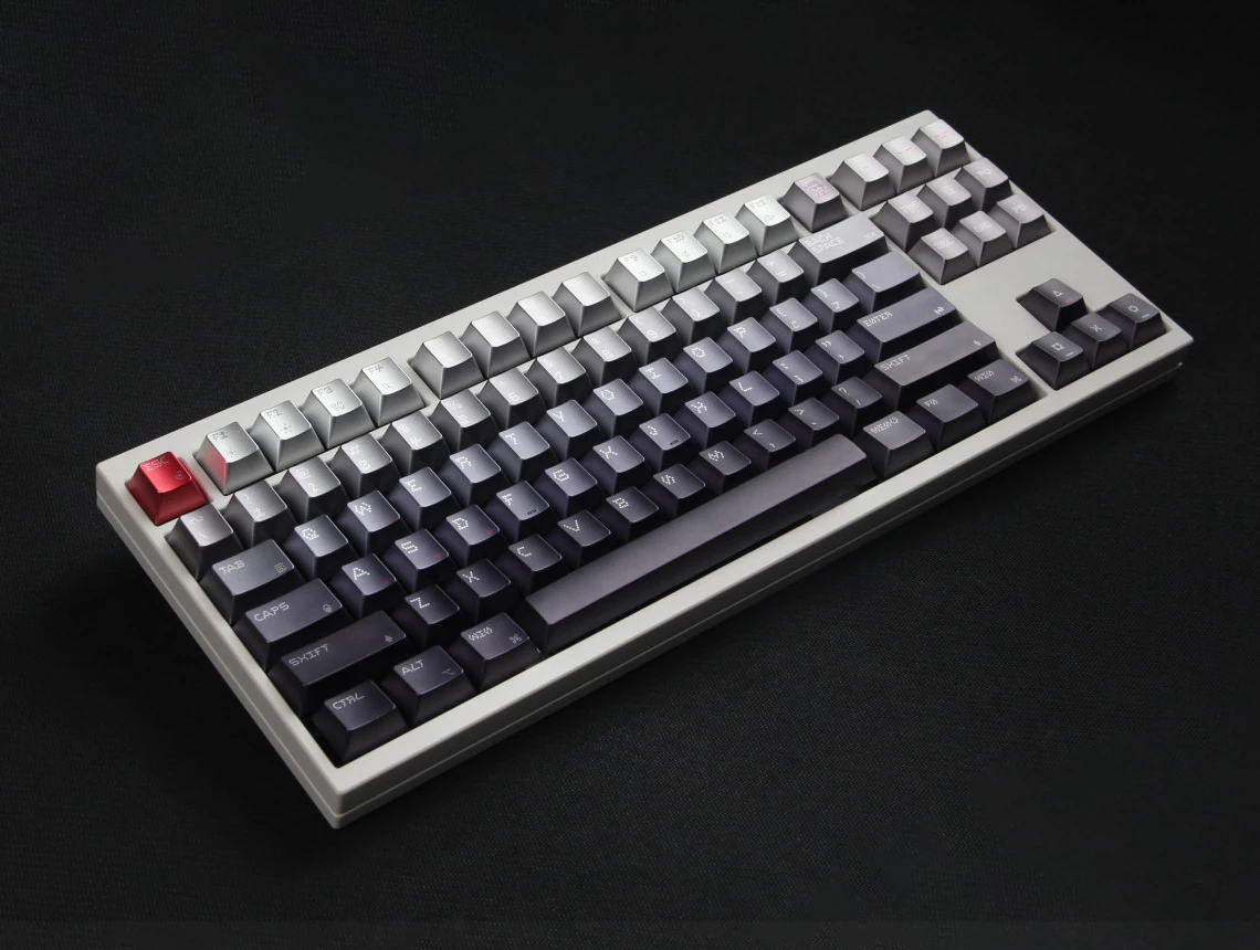 Wide angled keyboard with light upper rows, darker lower rows, and a red Esc key.
