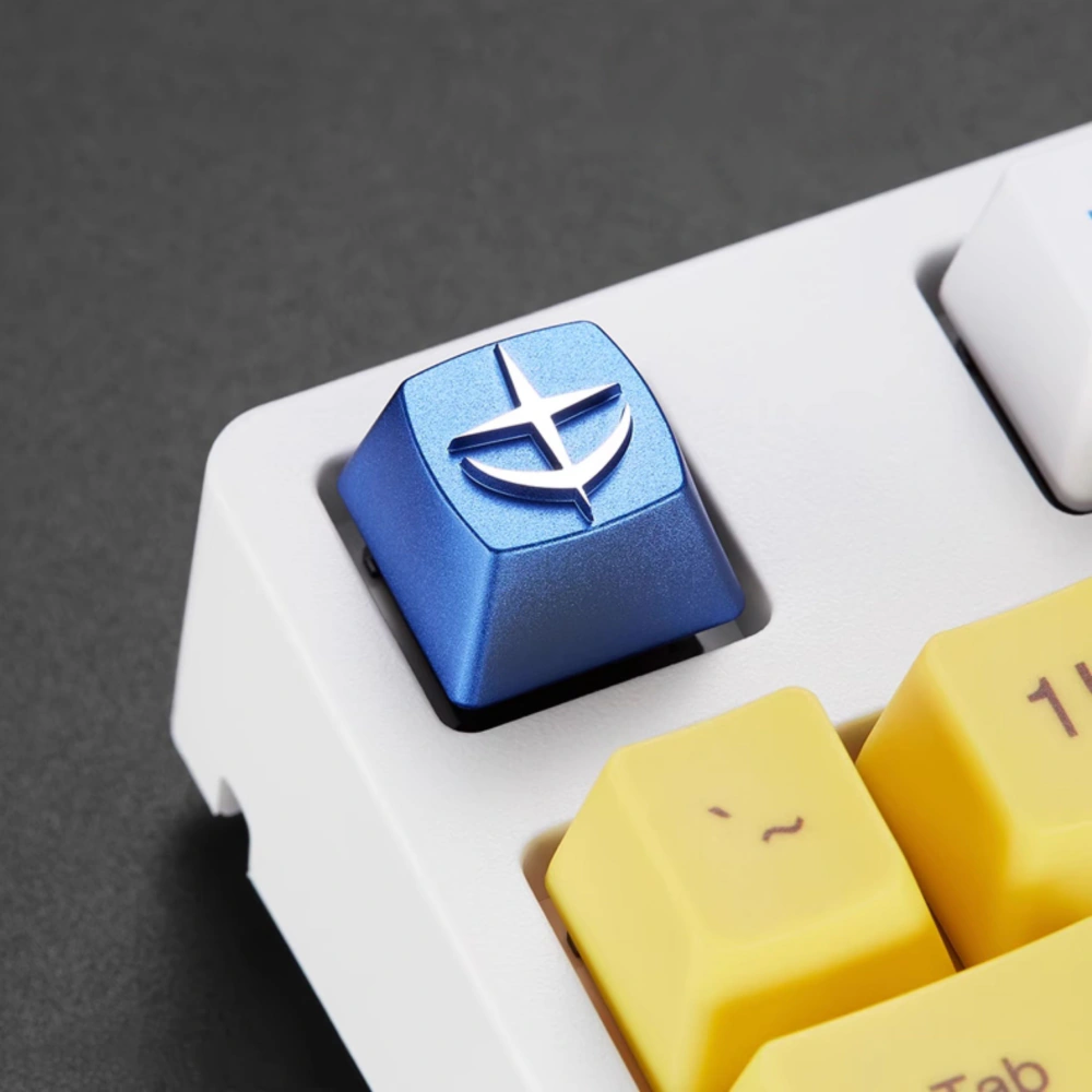 E.F.S.F. Emblem Aluminum Artisan Keycap Blue E.F.S.F. emblem keycap installed at an angle on a white mechanical keyboard.