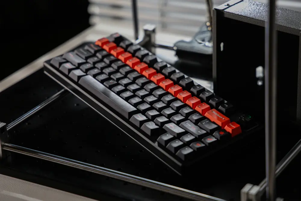 Full black keyboard with dark keycaps and an orange row, photographed at an angle.
