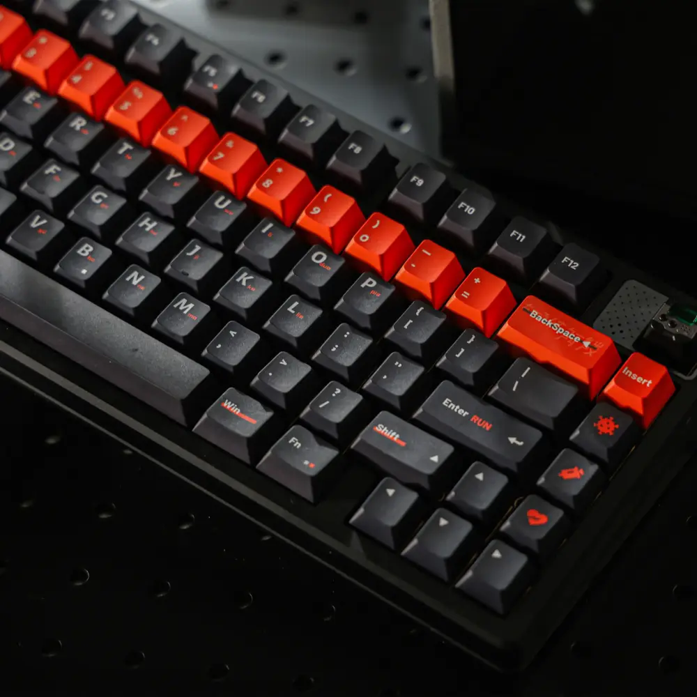 Black keyboard with dark keycaps and an orange number row and accent keys.