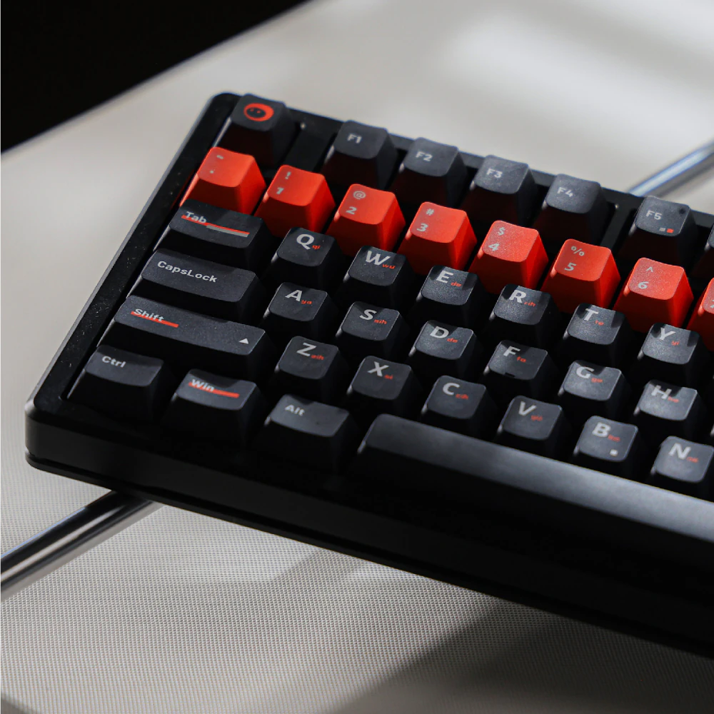 Left side of a black keyboard with orange number keys and orange Shift accents.