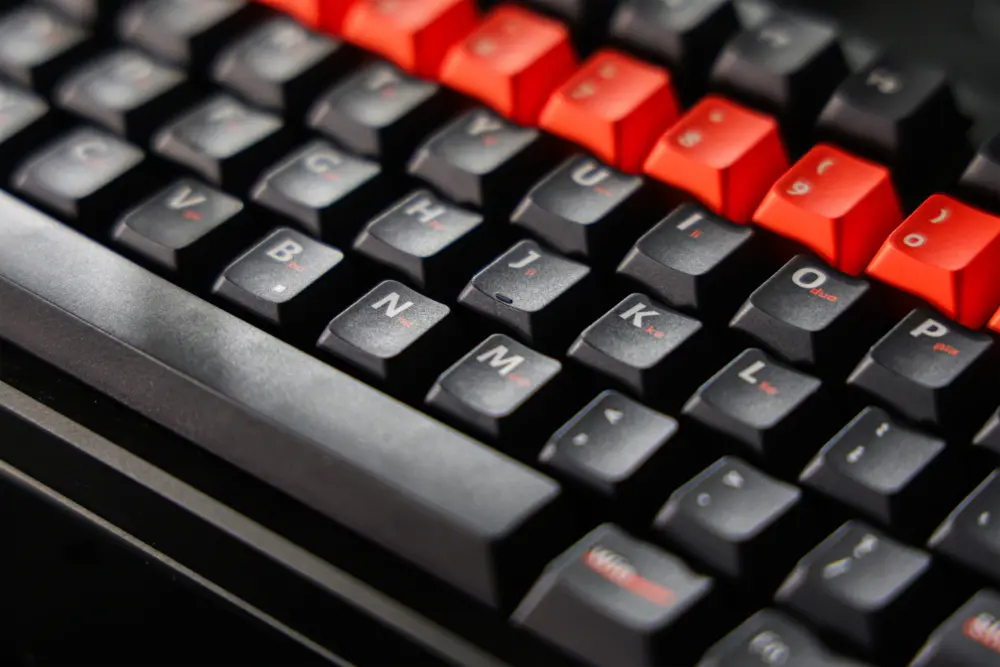 Dark letter keys with white Latin legends and smaller orange markings.