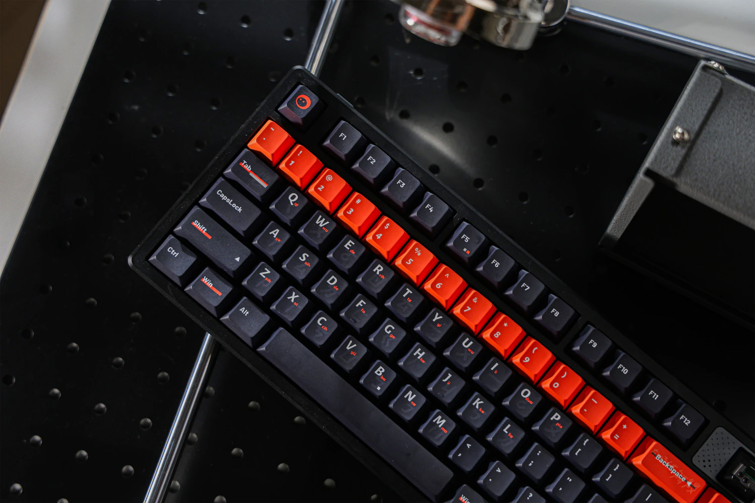 Angled overhead view of a black keyboard with dark and orange keycaps.
