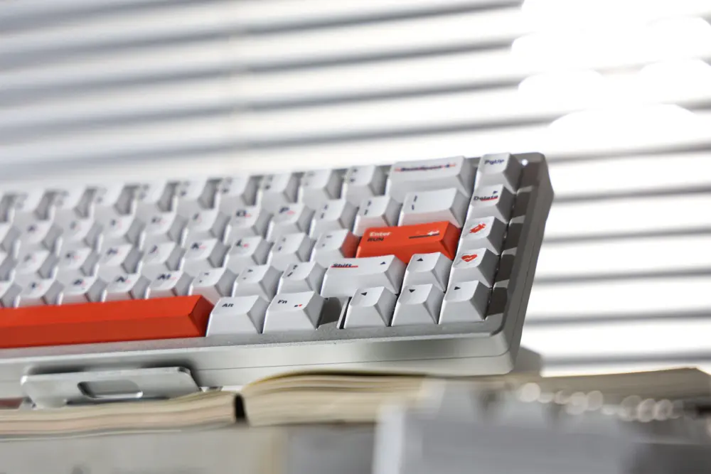 White keyboard with orange accents photographed from a low angle.
