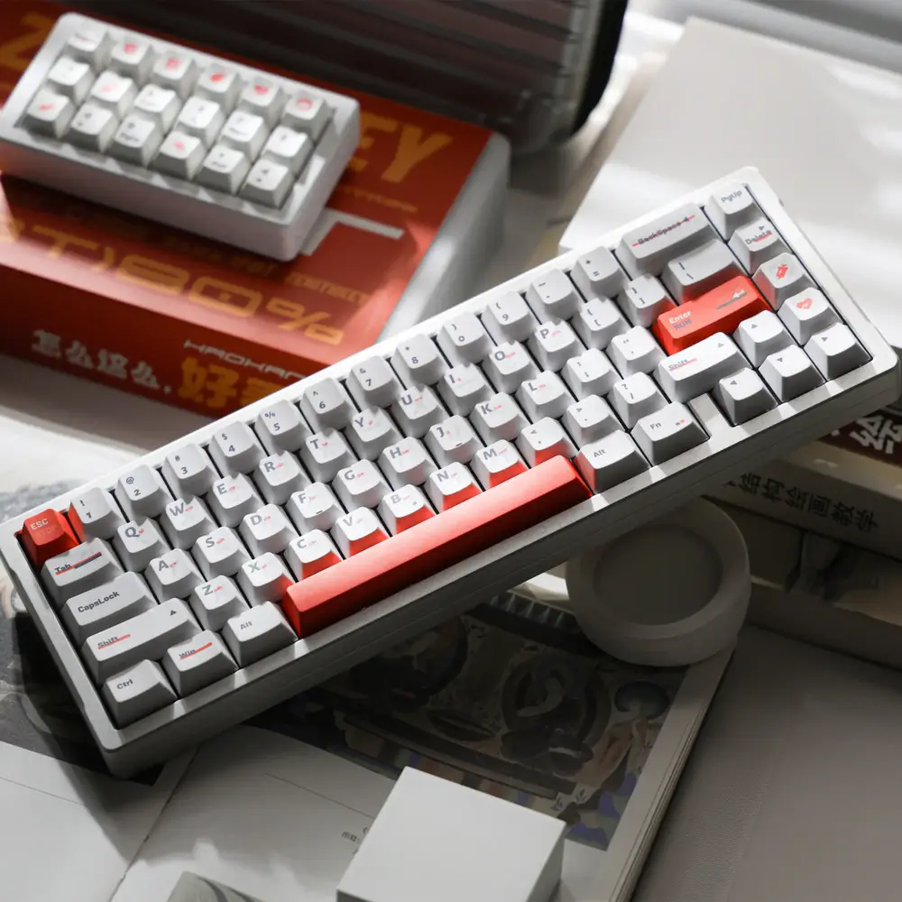 White keyboard with orange accent keys and a gray case, photographed from above.