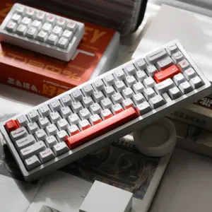 White keyboard with orange accent keys and a gray case, photographed from above.