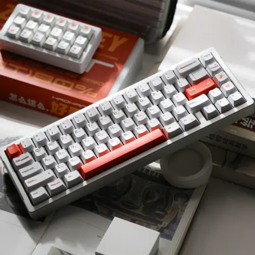 White keyboard with orange accent keys and a gray case, photographed from above.
