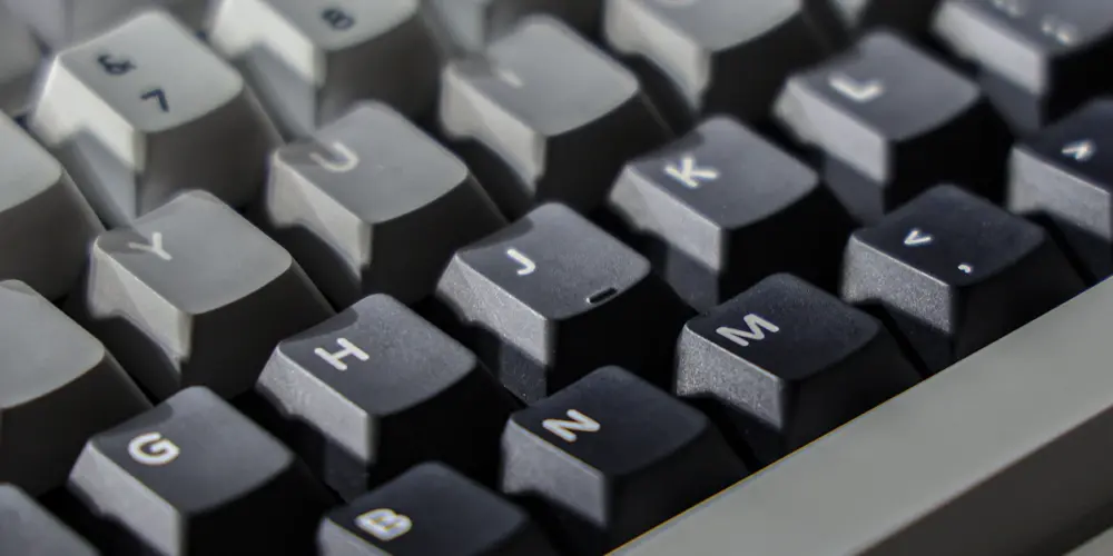 Close-up of individual dark gray keycaps with light-colored legends.