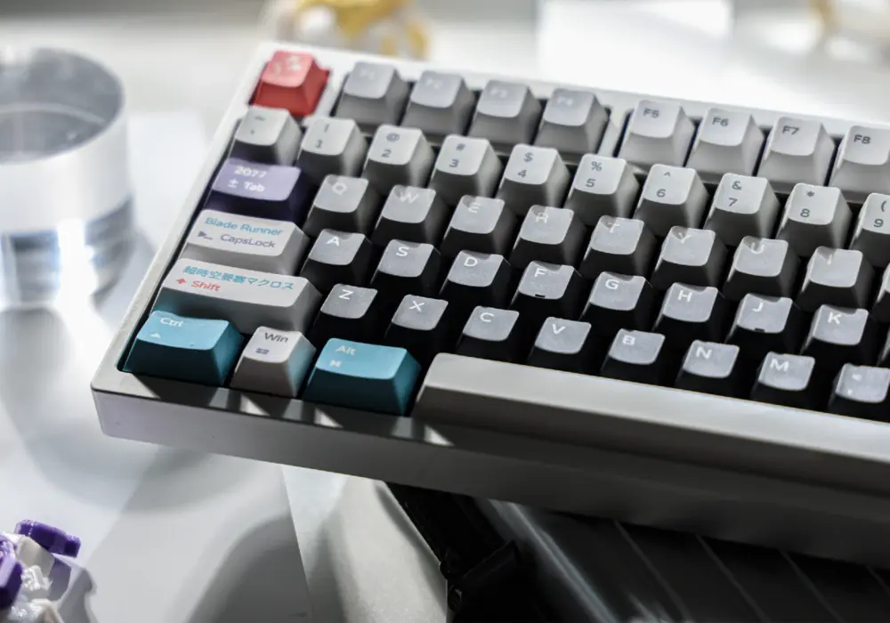 Keyboard photographed from the side with light and dark gray keycaps.