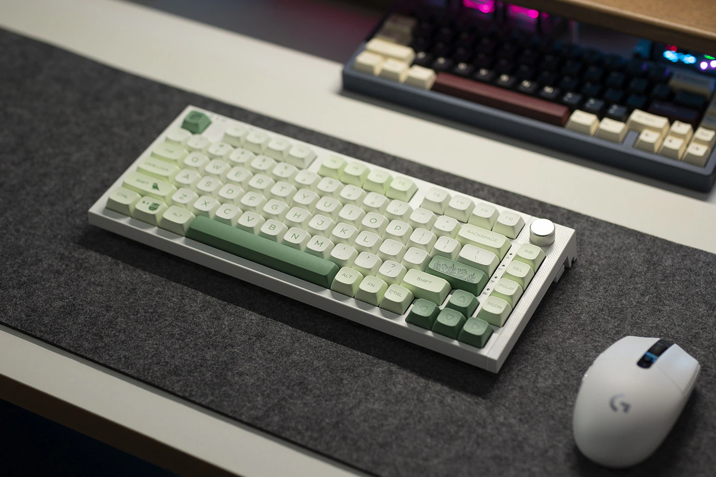 Green Botanical Keycaps Desk Setup Wide desk view of a keyboard with green and white botanical keycaps on a dark mat.