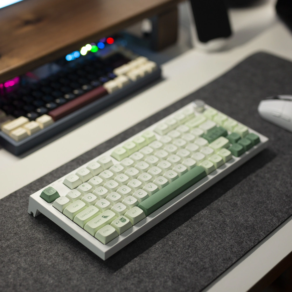 Green Botanical Keycaps Desk View Compact keyboard with green and white botanical keycaps on a dark desk mat.