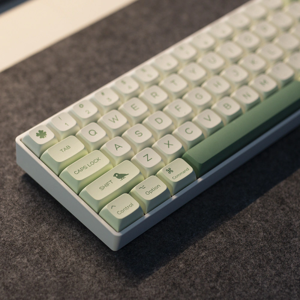 Green Botanical Keycaps Left Corner Detail Close view of the left side of a compact keyboard with green botanical keycaps and animal accents.