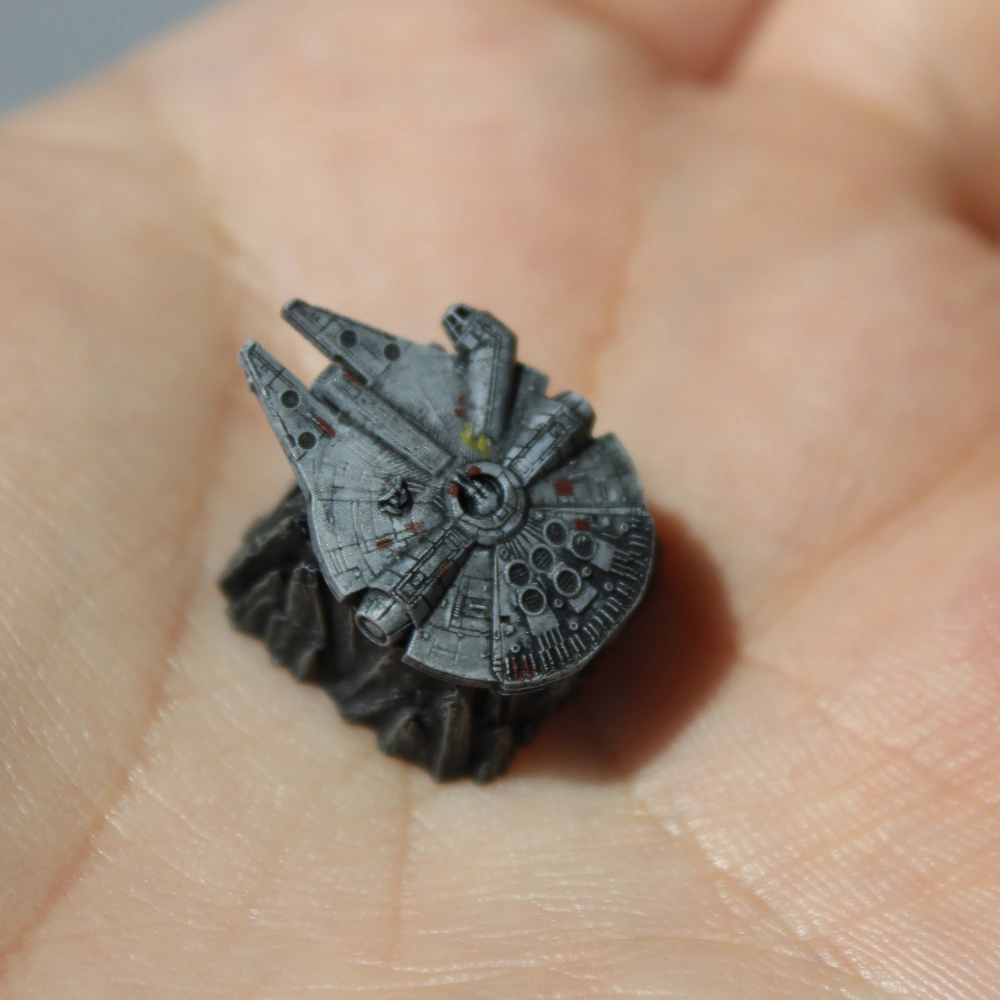 Millennium Falcon Keycap in Hand Gray Millennium Falcon keycap resting in an open palm, with small red and yellow accents.
