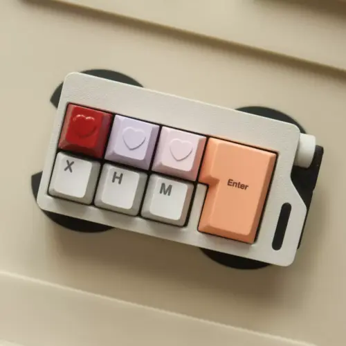 Compact keyboard with red, lavender, and pink heart keycaps.