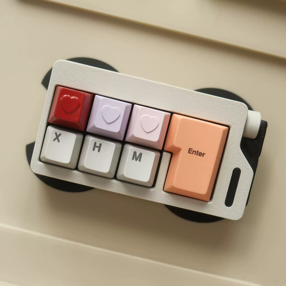 Compact keyboard with red, lavender, and pink heart keycaps.