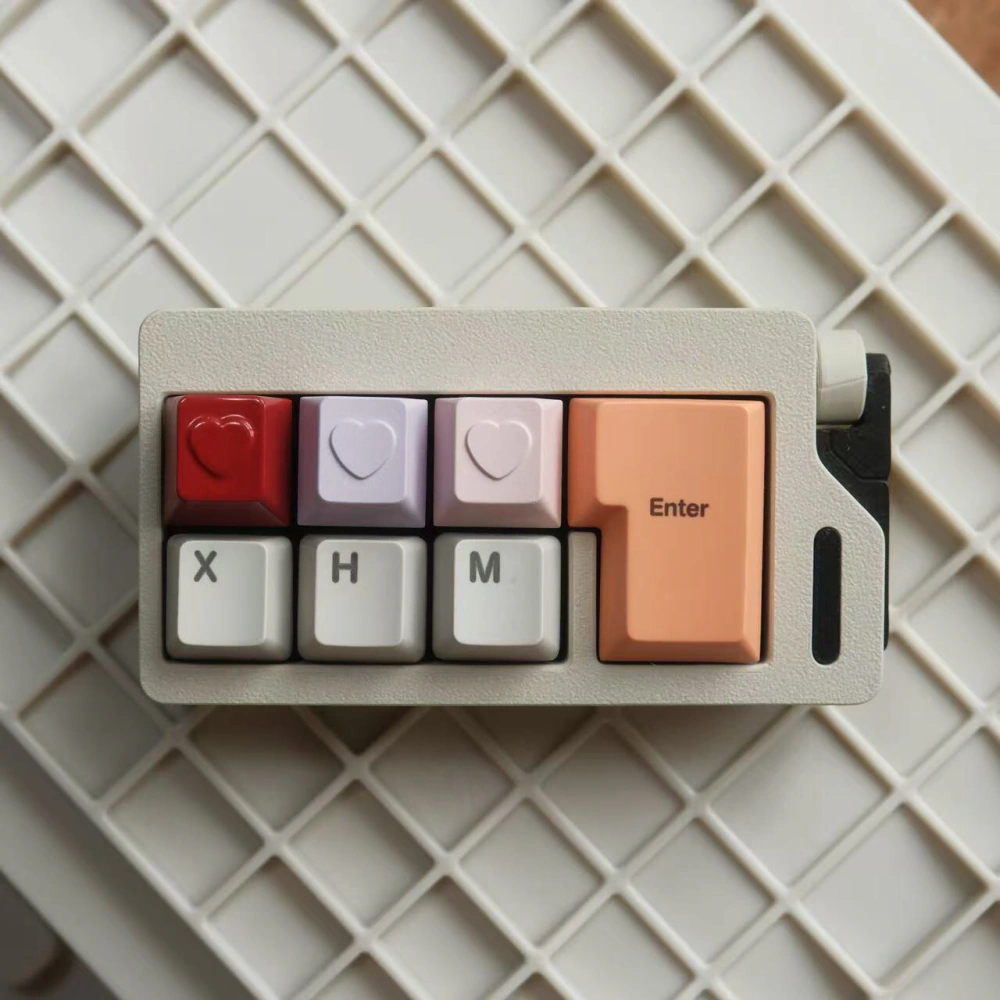 Three heart-shaped keycaps installed across the top row of a compact keyboard.