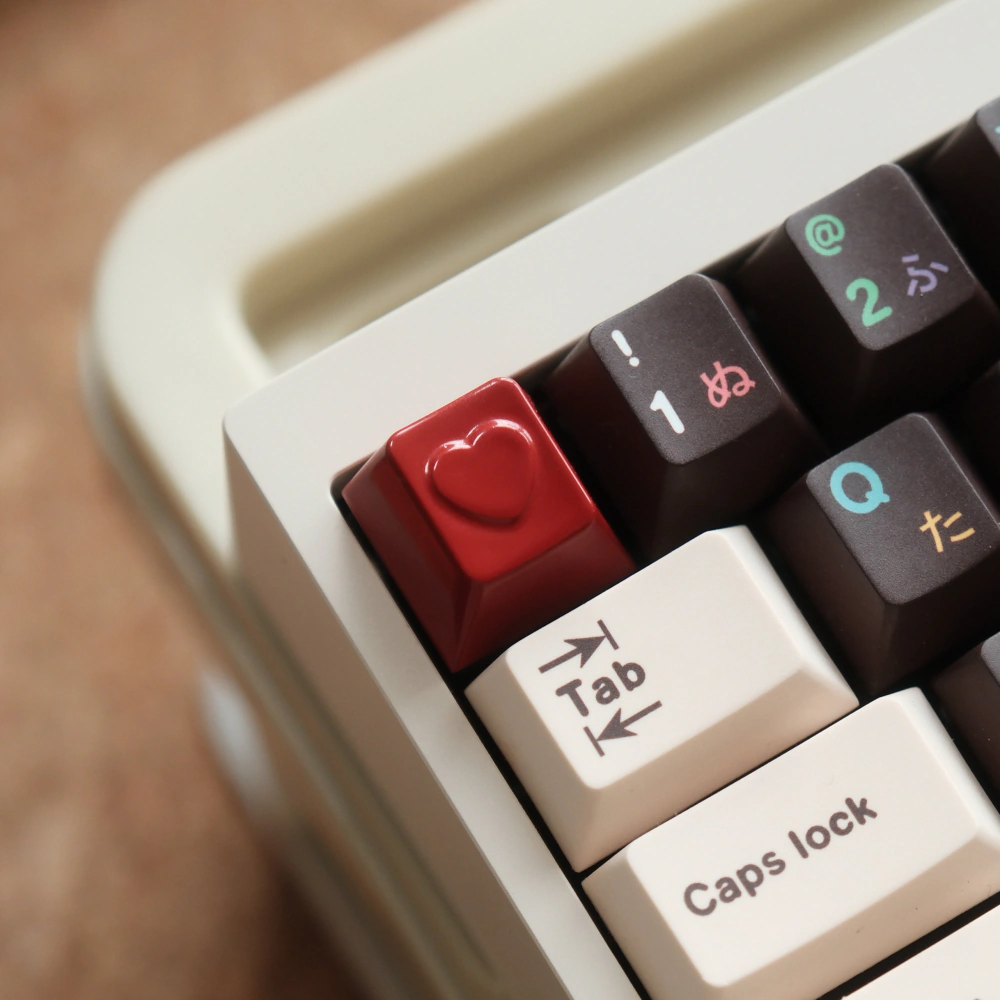Red heart-shaped keycap beside printed keyboard keys.