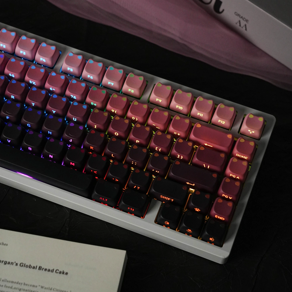 Backlit pink-black keycaps with illuminated cat-ear shapes and side-printed legends