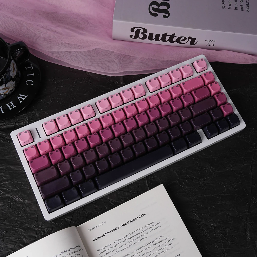 Pink, purple, and black gradient keycaps arranged on a white keyboard