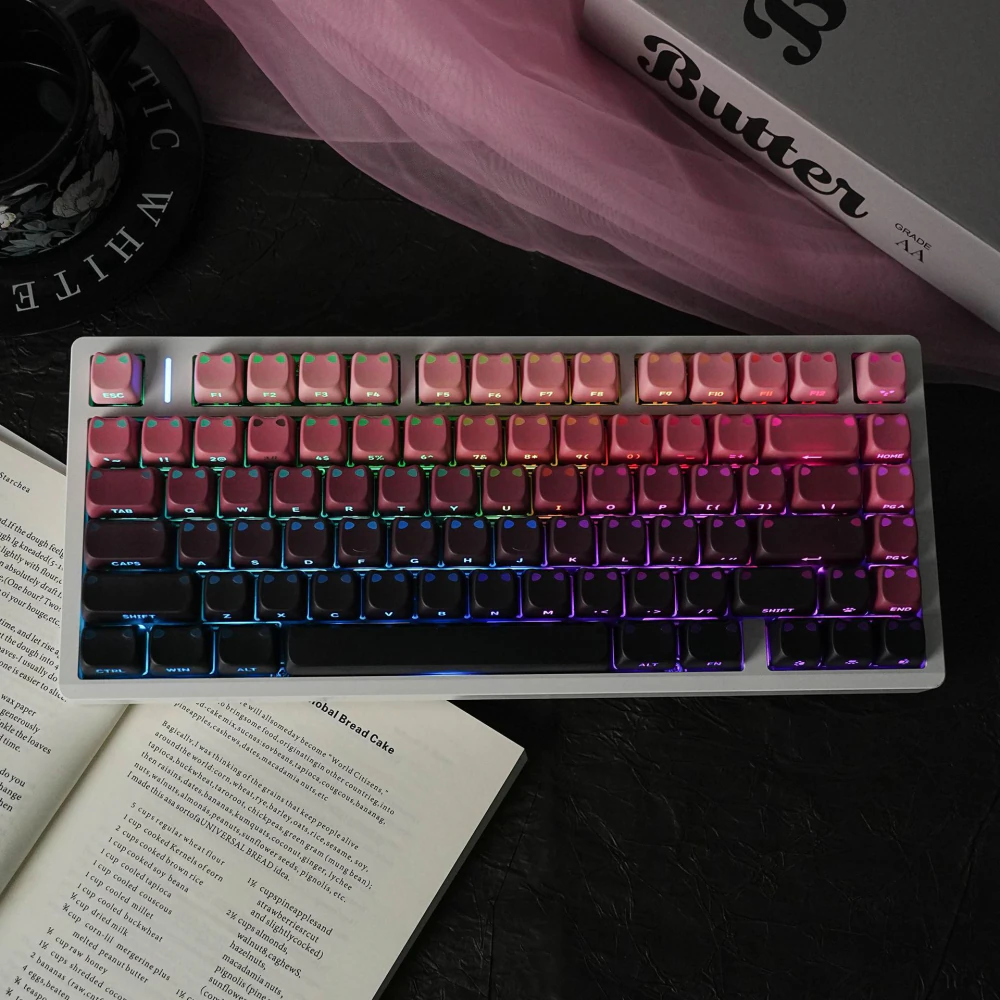 Pink-black MAO profile keycap set displayed with extra keycaps in a tray