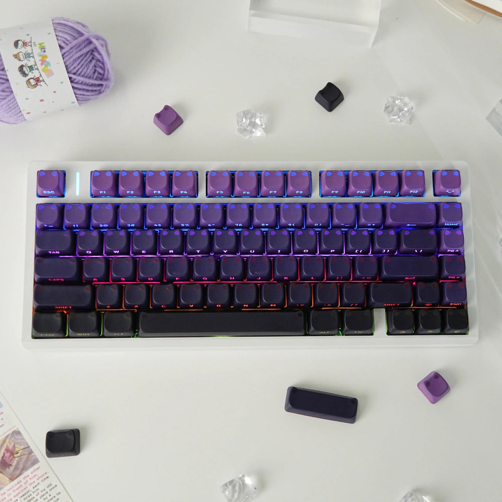 Purple-to-black gradient cat-ear keycaps arranged on a white keyboard