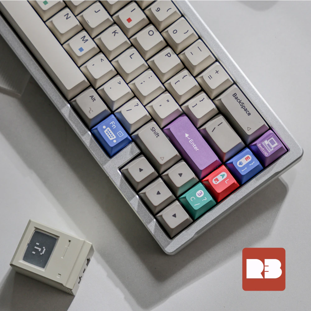 Keyboard in a silver case with a small beige computer model at the lower left.
