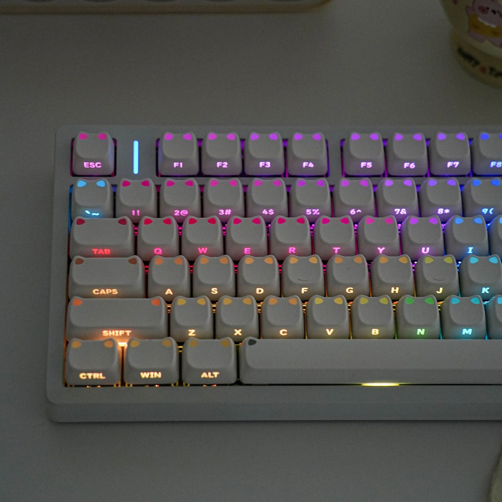 Backlit White Cat-Ear Keycaps Backlit white keycaps with illuminated raised cat-ear shapes and side-printed legends