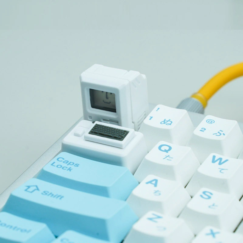 White Macintosh-style cap and small keyboard piece installed on a keyboard with Japanese legends.