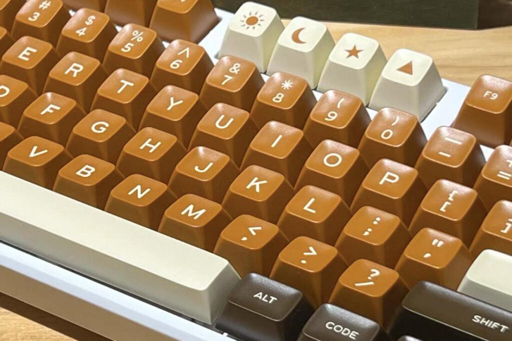 Brown and cream keycaps with tall rounded tops on a keyboard