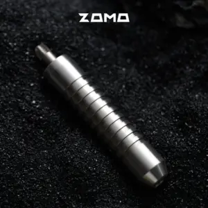 ZOMO Adjuster Cover On Dark Background A silver grooved ZOMO adjuster lies diagonally on a black textured surface.
