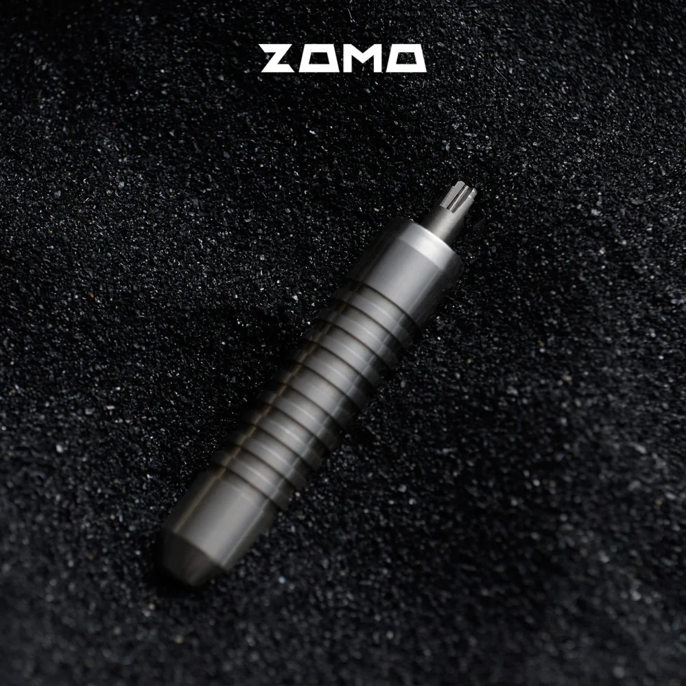 The silver adjuster lies diagonally with its cross-shaped tip visible against a dark background.