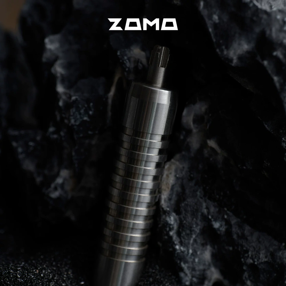 An upright silver adjuster with a grooved handle and cross-shaped tip on a dark rocky surface.